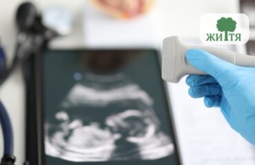 Gloved hand holding an ultrasound probe over a diagnostic ultrasound image on a monitor, with a logo featuring a tree in the corner.